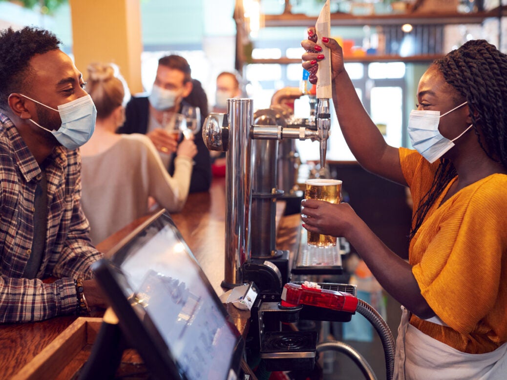 confidence post-pandemic. Image shows a person ordering a drink in a bar