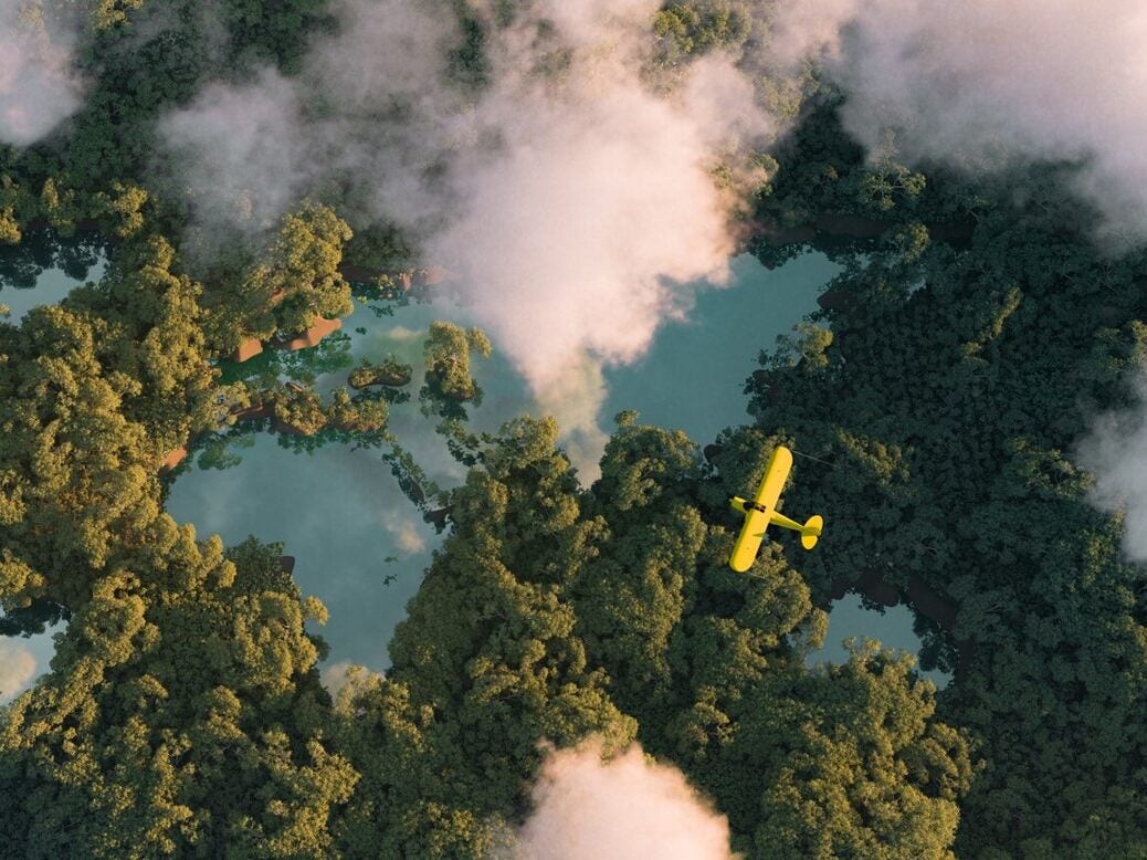 light-aircraft flying over forest with lakes shaped like the earth